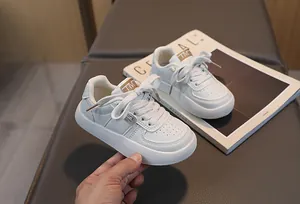 Détail des baskets blanches en cuir pour enfants avec perforations latérales et coutures