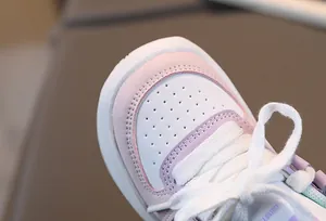 Vue détaillée du bout perforé et des coutures sur cette chaussure blanche pour enfants