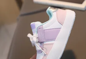 Gros plan sur les baskets enfant roses et blanches montrant les coutures et les détails