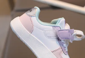 Détail de baskets enfant aux couleurs macaron avec fermeture velcro et tirette talon