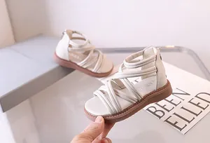 Detailansicht der cremefarbenen Römersandalen mit Kreuzriemen und Reißverschluss
