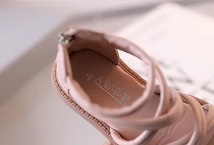 Detail rosa Mädchen-Römersandalen mit überkreuzten Lederriemen und Reißverschluss hinten