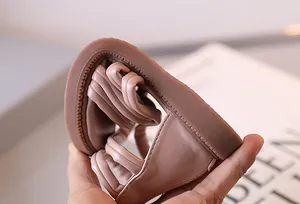Nahaufnahme der extremen Flexibilität der weichen rosa Ledersohle der Mädchensandale
