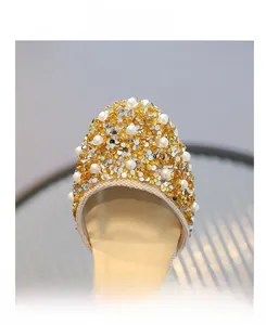 Detail view of girls' princess shoes featuring white pearls and golden rhinestones