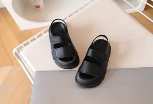 Top view of black children's sandals featuring dual straps and non-slip textured soles