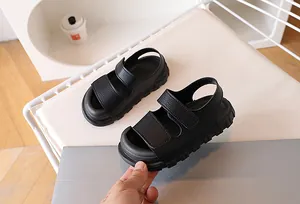 Detailed view of kids' black leather sandals with double Velcro straps and thick non-slip soles