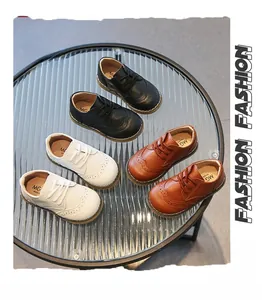Dettaglio di scarpe brogue per bambini in nero bianco e marrone con decorazioni