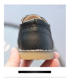 Dettaglio del tallone di supporto su scarpe in pelle nera per bambini con fori