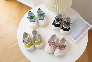 Top view of girls canvas Mary Jane shoes with plaid bows and floral charms in various colors
