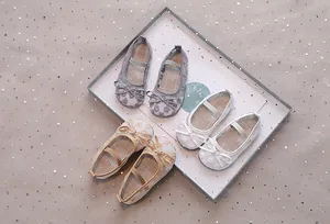 Gedetailleerd bovenaanzicht van ademende mesh baby Mary Janes met kantbloemen en strikjes