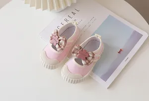 Detail of pink toddler canvas shoes with brown plaid bow and floral fashion emblem
