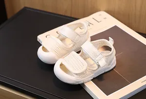 Détail de sandales blanches en maille pour bébé avec bout en caoutchouc et bande velcro