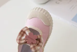 Detail of pink canvas toddler shoe with checkered bow and protective rubber toe cap