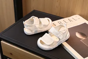 Détail de sandales pour bébés en maille respirante avec sangles velcro de couleur crème