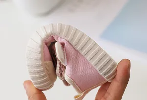 Close-up showing the flexible rubber sole and soft pink canvas of toddler shoes