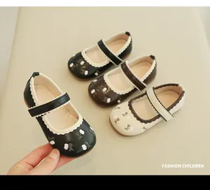 Detail of girls' Mary Jane shoes featuring floral embroidery and scalloped edge trim
