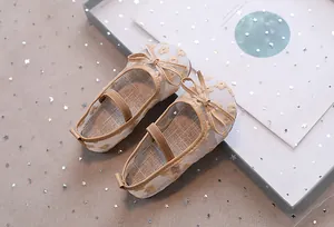 Detail van mesh Mary Jane schoenen voor meisjes met gele bloemenborduurwerk en een strik