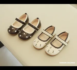 Detail of girls' Mary Jane shoes with floral embroidery and scalloped edges in two colors