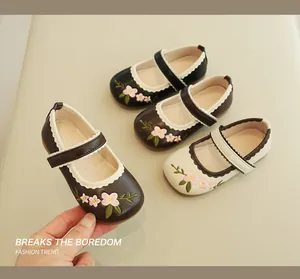 Close-up of floral embroidery and scalloped edges on girls' Mary Jane leather shoes