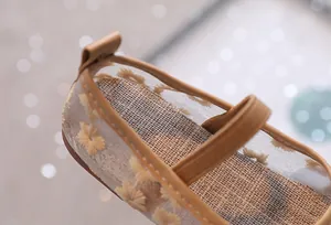 Detail van bloemenborduurwerk op ademende mesh kinderschoenen met linnen binnenzool