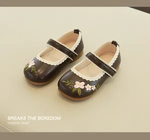 Close-up of children's Mary Jane shoes with floral embroidery and lace trim detail