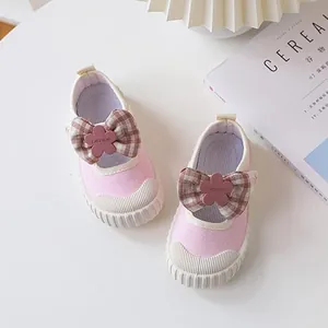 Pink canvas shoes for girls with plaid bow and flower buckle on white background