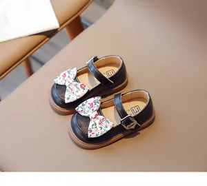 Draufsicht auf schwarze Mädchen-Mary-Janes mit floraler Schleife und Metallschnalle