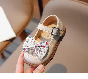Nahaufnahme beiger Mädchen-Mary-Jane-Schuh mit floraler Schleife und Spitzenverzierung