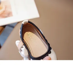 Nahaufnahme der Mary Jane Mädchenschuhe mit schwarzem Wellenrand und goldener Innensohle