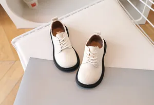 Detail view of cream matte leather children shoe with round toe and black rubber sole