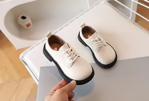 Close-up of matte cream leather kids shoe featuring a thick black non-slip sole