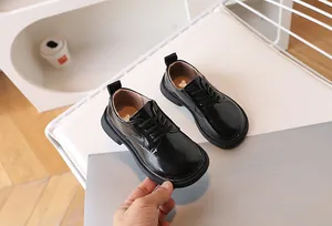 Close-up of black glossy patent leather children's dress shoes with anti-slip rubber soles