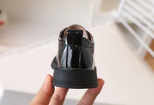 Close-up of black patent leather kids shoe heel with durable non-slip rubber sole