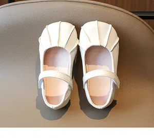 Detalle de merceditas blancas para niña con pliegues en forma de concha en la puntera