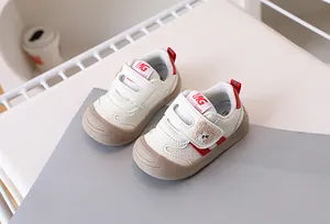 Detailed close-up of baby walking shoes with bear embroidery and hook-and-loop closure