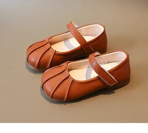 Detalle de zapatos Mary Jane caramelo con puntera fruncida y tira de cierre adhesivo