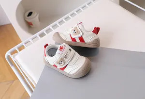 Detail of baby walking shoes featuring bear embroidery and breathable perforated leather