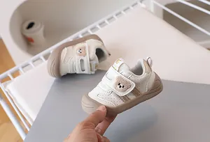 Detail view of baby walker shoes featuring bear embroidery and non-slip rubber soles