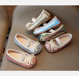 Close-up of glitter girls Mary Jane flats in six shiny colors with bow detail