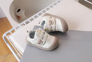 Macro view of baby sneakers featuring soft teddy bear embroidery and velcro strap closure