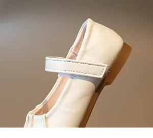 Primer plano de zapatos Mary Jane crema para niña con cuero plisado y cierre de velcro