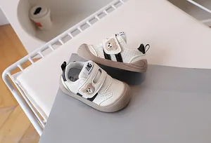 Close-up of beige baby walking shoes with cute bear embroidery and hook-and-loop straps