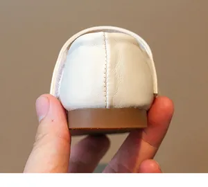 Primer plano del talón y la textura del cuero de los zapatos blancos de niña