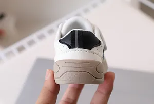 Close-up of baby walking shoes showing the heel thickness and brown anti-slip sole detail