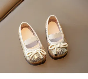 Detailed macro view of girls' gold sequin Mary Jane shoes with delicate bow and elastic strap