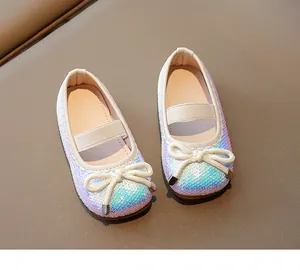 Close-up of girls' sparkling sequin Mary Jane shoes with cream bow and elastic strap