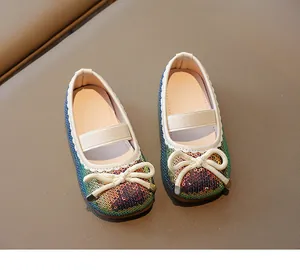 Macro shot of glittery rainbow sequins and bow detail on toddler Mary Jane shoes