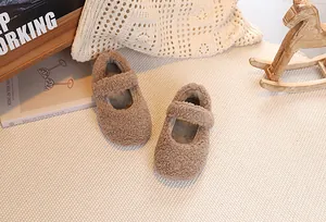Close-up of brown plush Mary Jane shoes for children with soft lamb wool texture