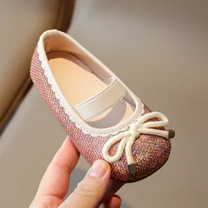 Sparkly pink glitter Mary Jane shoes for girls with white bow and elastic strap details
