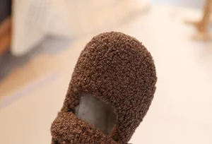 Close-up of plush dark brown sherpa fleece texture and warm lining on children's winter shoes